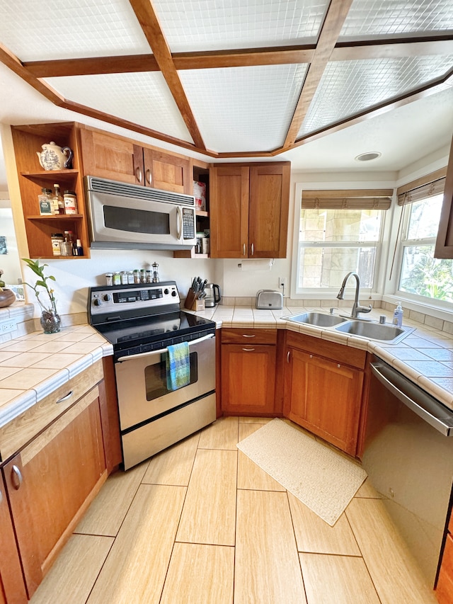 kitchen featuring appliances with stainless steel finishes, tile countertops, and sink