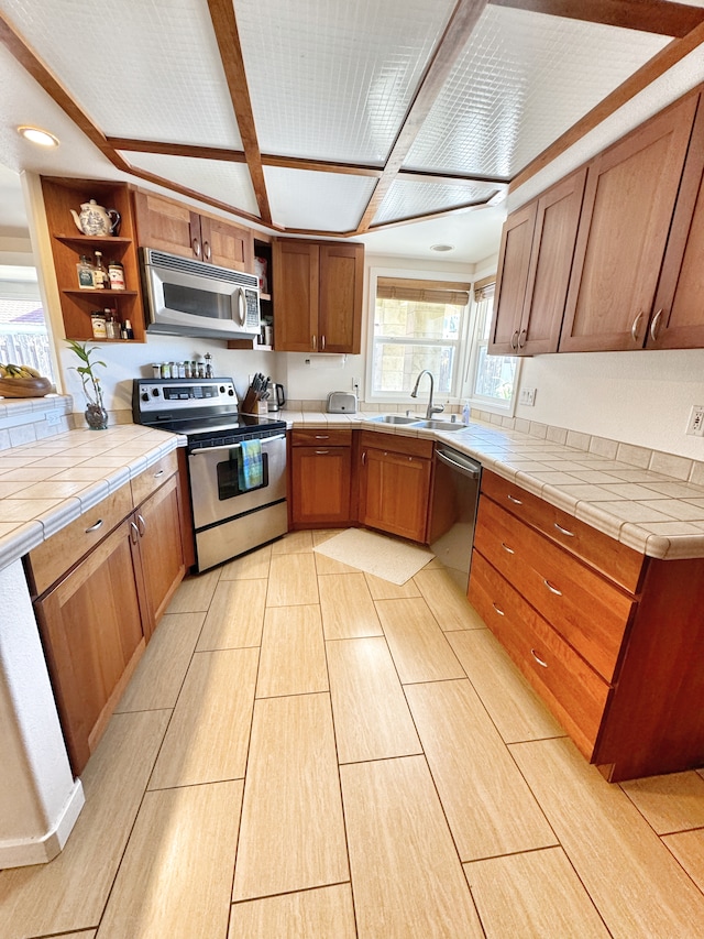 kitchen with stainless steel appliances, tile countertops, and sink