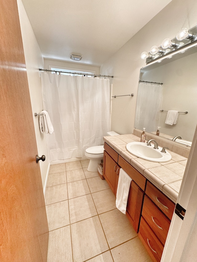 bathroom featuring tile patterned flooring, toilet, and vanity