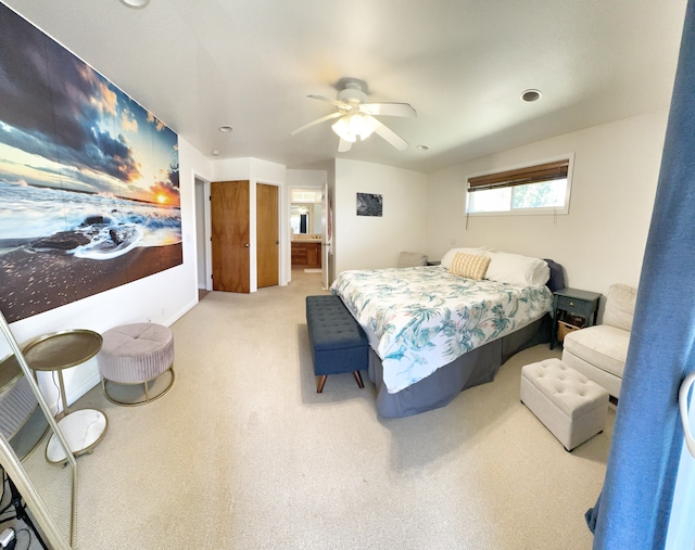 carpeted bedroom featuring ensuite bath and ceiling fan