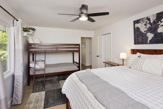 bedroom with a textured ceiling, ceiling fan, and a closet