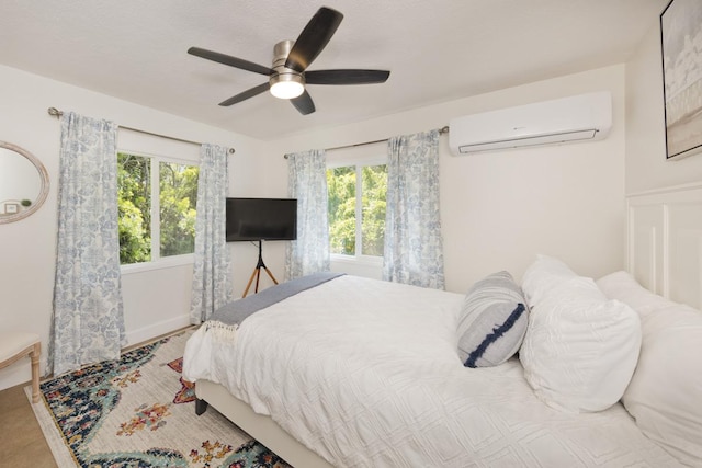 bedroom with a wall mounted air conditioner and ceiling fan