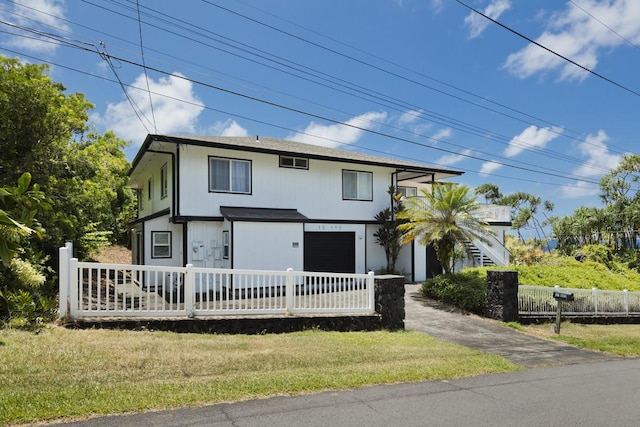 view of front of home with a garage and a front lawn