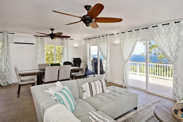 tiled living room featuring a water view, a wall mounted AC, and a textured ceiling