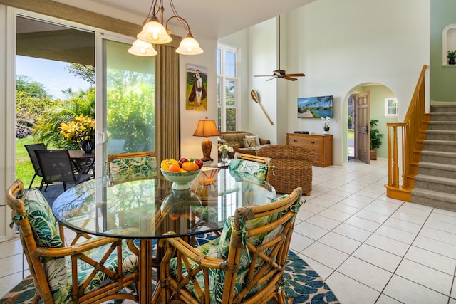 tiled dining area with a towering ceiling and ceiling fan