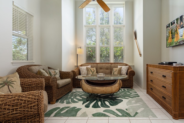 living area with a healthy amount of sunlight, light tile patterned floors, and ceiling fan