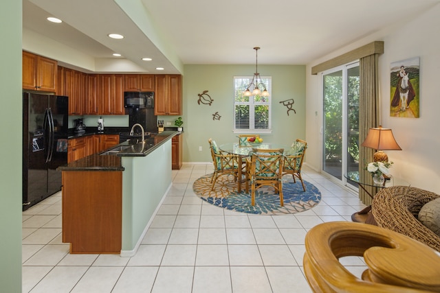 kitchen with pendant lighting, an island with sink, sink, light tile patterned floors, and black appliances