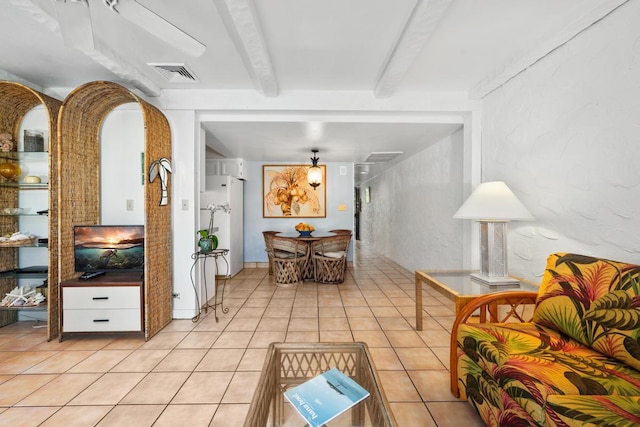 interior space featuring light tile patterned flooring and beam ceiling