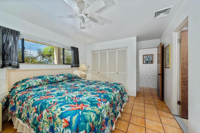 tiled bedroom with ceiling fan and a closet