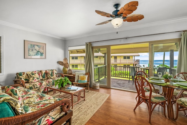 living room featuring crown molding, hardwood / wood-style flooring, a water view, and ceiling fan