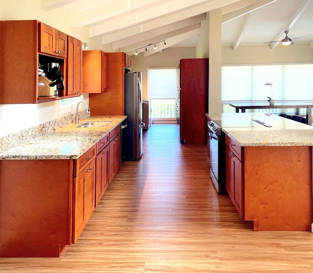 kitchen with light hardwood / wood-style floors, light stone countertops, stainless steel appliances, ceiling fan, and sink