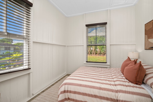 bedroom with ornamental molding and light wood-type flooring