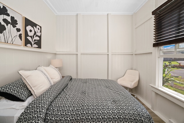 bedroom featuring multiple windows, crown molding, and wood-type flooring