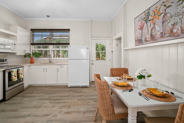 kitchen with white cabinets, light hardwood / wood-style floors, white appliances, and sink