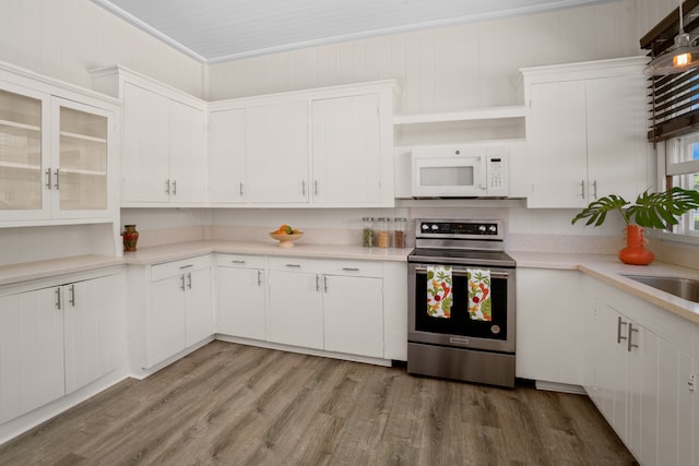 kitchen with white cabinets, ornamental molding, hardwood / wood-style floors, and stainless steel electric range oven