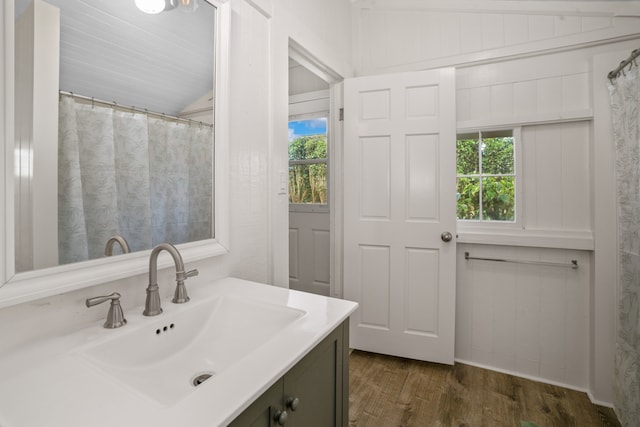 bathroom with vanity, wood-type flooring, and vaulted ceiling