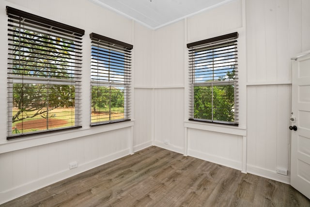 unfurnished room with dark wood-type flooring and crown molding