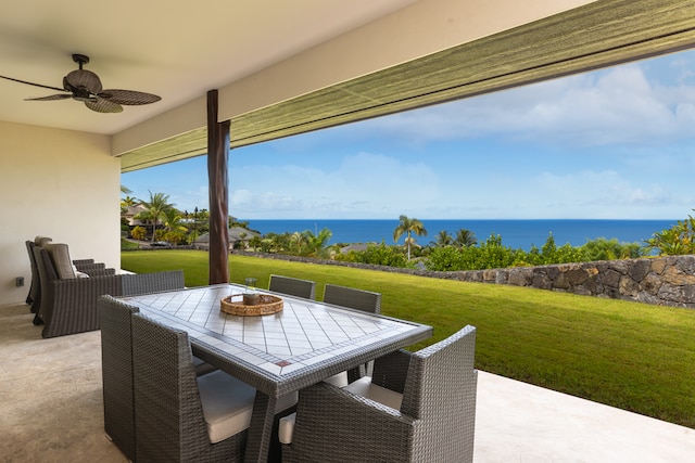 view of patio featuring a fire pit, ceiling fan, and a water view