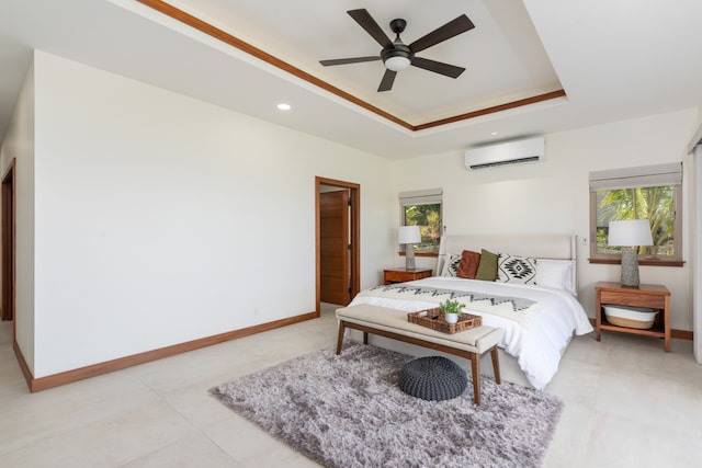 bedroom featuring multiple windows, an AC wall unit, a raised ceiling, and ceiling fan