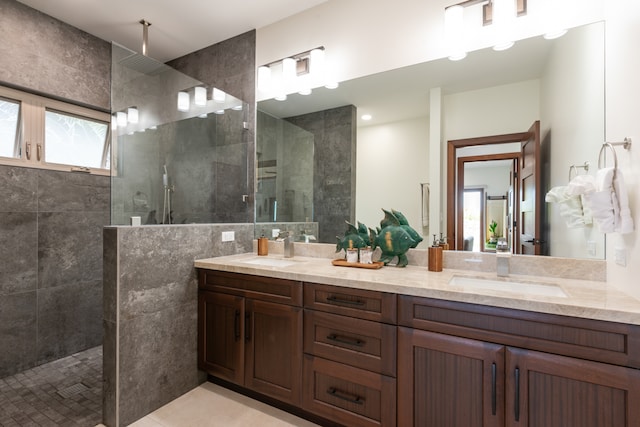 bathroom featuring a wealth of natural light, vanity, tile patterned flooring, and a tile shower