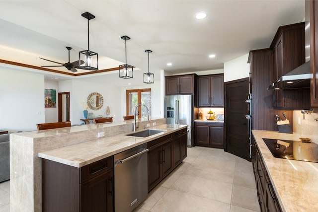 kitchen featuring decorative light fixtures, stainless steel appliances, sink, wall chimney range hood, and ceiling fan