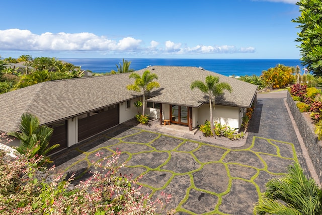 exterior space featuring a garage and a water view