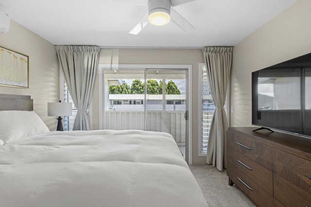 bedroom featuring access to exterior, light carpet, a wall unit AC, and a ceiling fan