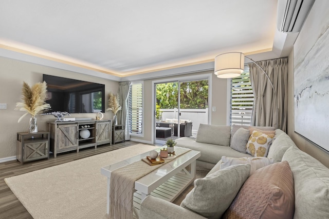 living area featuring a tray ceiling, dark wood-style flooring, and baseboards