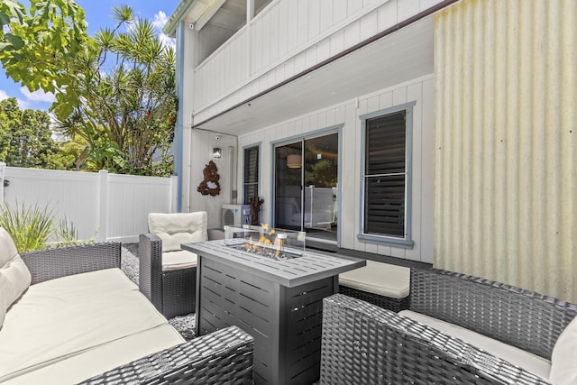 wooden deck with a patio area, an outdoor living space with a fire pit, and fence