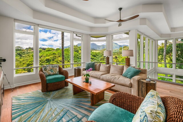 sunroom featuring a wealth of natural light, ceiling fan, and a tray ceiling