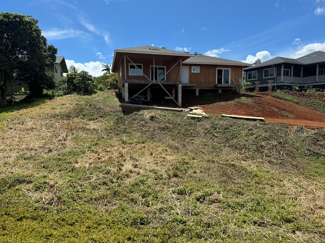 rear view of house featuring a yard