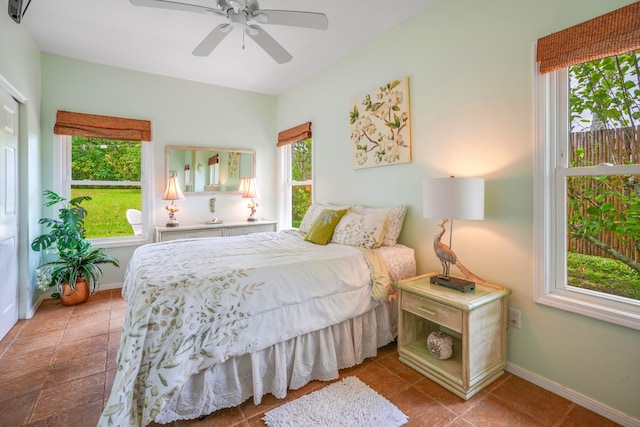 tiled bedroom featuring multiple windows and ceiling fan