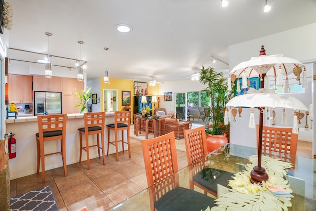 dining area featuring track lighting, light tile patterned floors, and ceiling fan