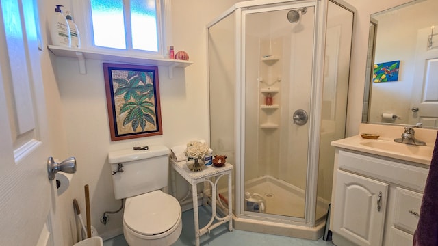 bathroom with vanity, a shower with door, and toilet