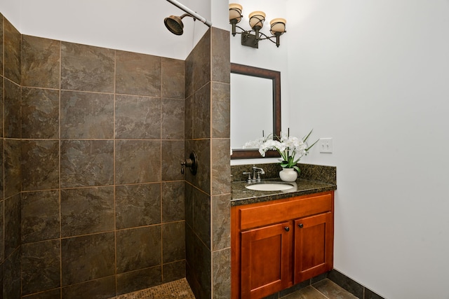 bathroom featuring a tile shower, vanity, and tile patterned flooring