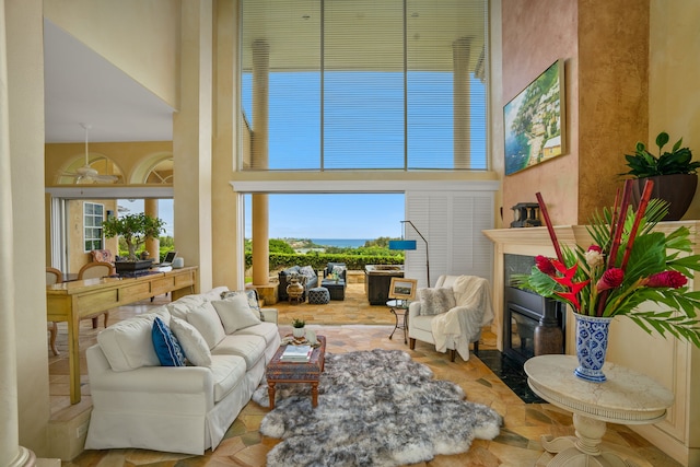 living room featuring a tiled fireplace and a towering ceiling