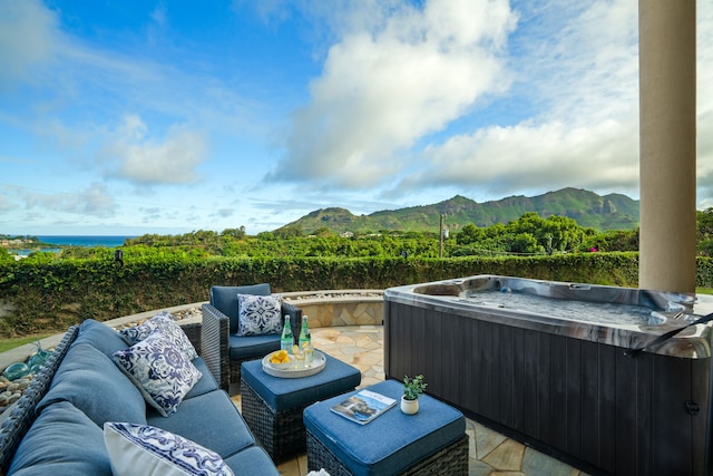 exterior space with a hot tub, an outdoor hangout area, and a mountain view