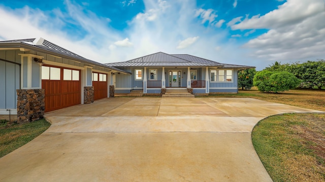 view of front of property with metal roof, a porch, a garage, board and batten siding, and a standing seam roof