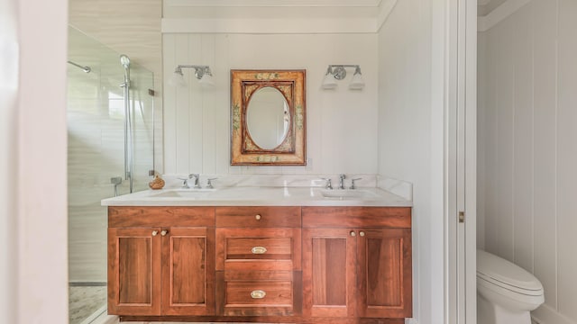 bathroom with a sink, double vanity, a shower stall, and toilet