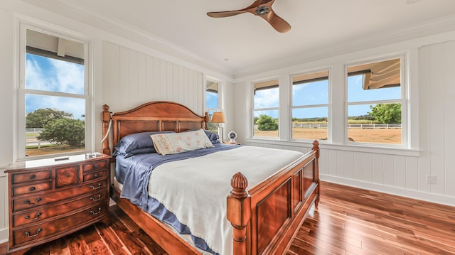 bedroom with wood-type flooring, a ceiling fan, and crown molding