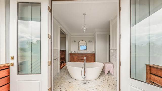 bathroom featuring a freestanding bath, a wainscoted wall, vanity, and tile walls