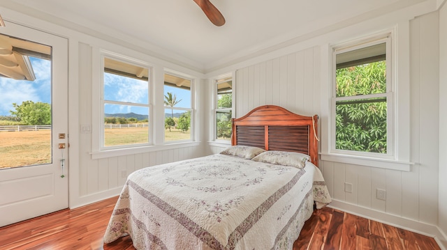 bedroom with access to exterior, a ceiling fan, baseboards, and wood finished floors