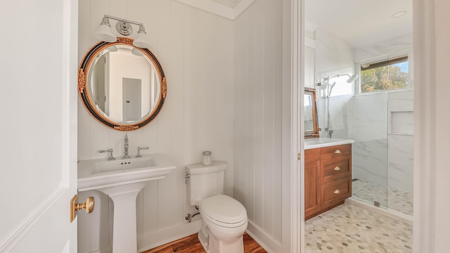 full bathroom featuring toilet, a marble finish shower, and a sink