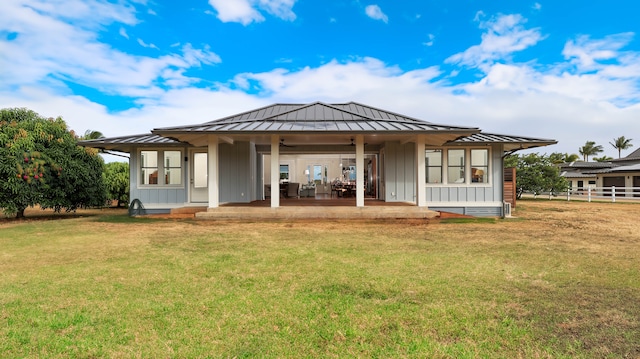 rear view of property featuring a lawn