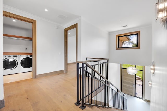 interior space featuring separate washer and dryer, light hardwood / wood-style floors, and ornamental molding