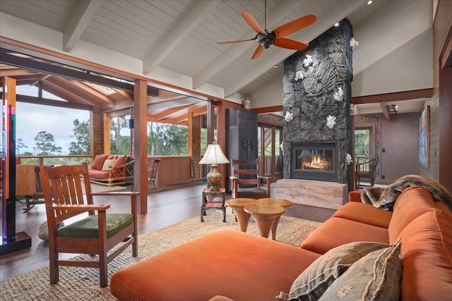 sunroom with vaulted ceiling with beams, a high end fireplace, ceiling fan, and wooden ceiling