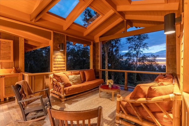 sunroom / solarium featuring vaulted ceiling with skylight and wood ceiling