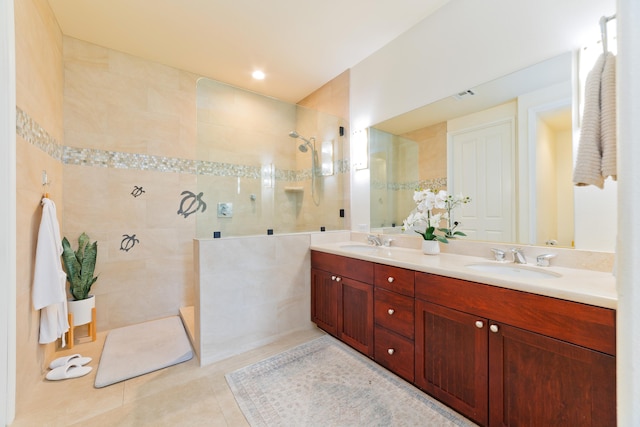 bathroom featuring tile patterned flooring, vanity, tile walls, and a tile shower