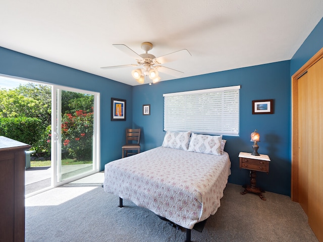 carpeted bedroom with a closet, multiple windows, ceiling fan, and access to exterior