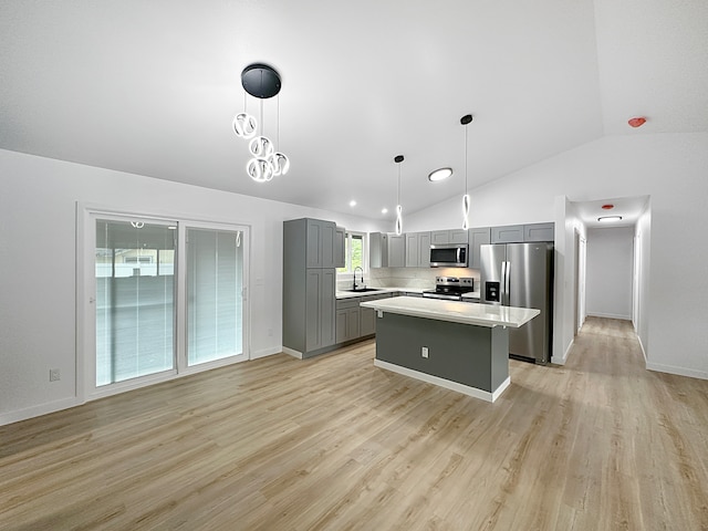 kitchen featuring pendant lighting, a kitchen island, stainless steel appliances, and gray cabinets